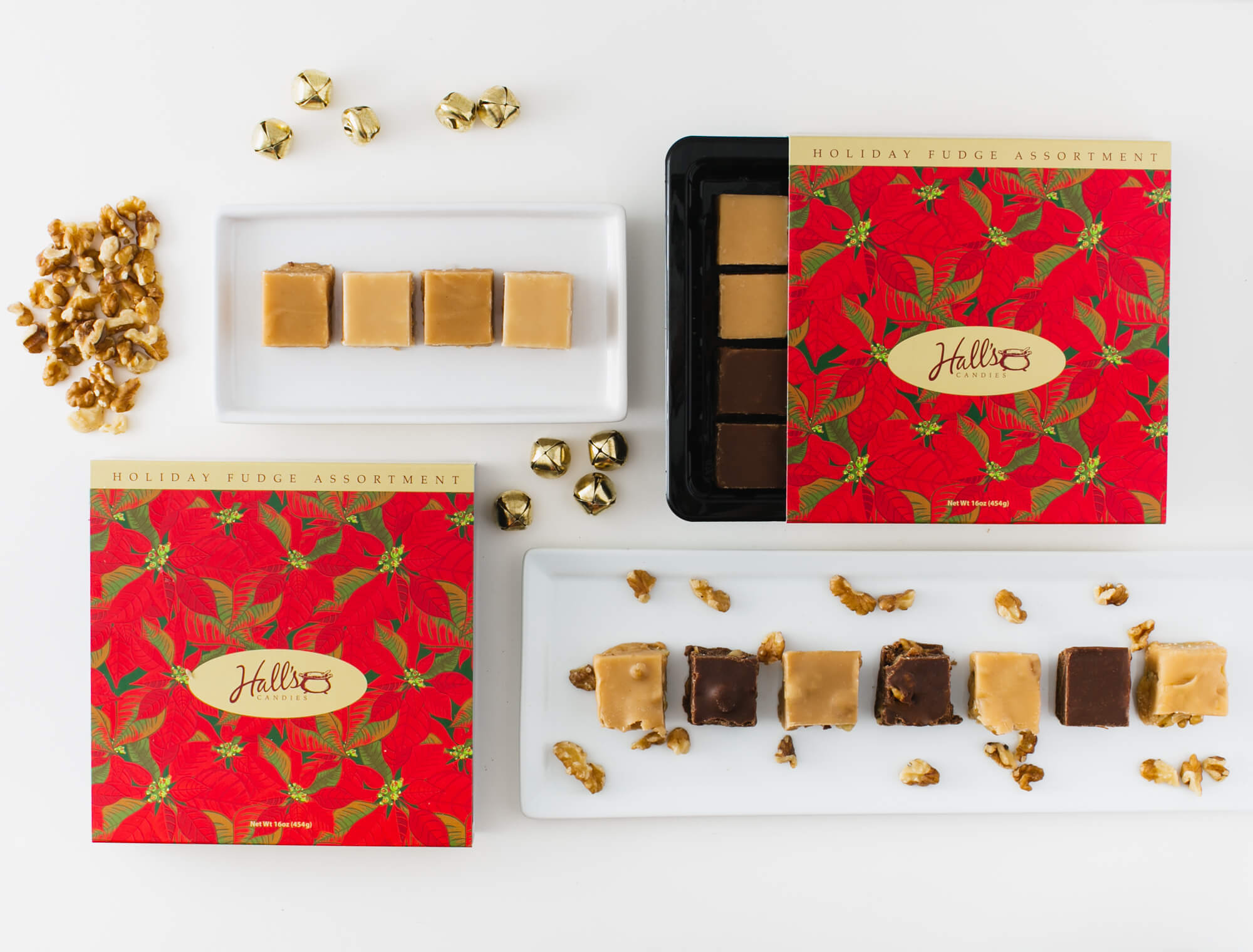festive arrangement of assorted fudge, walnuts, and gold jingle bells on white background